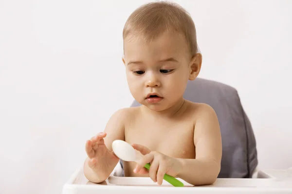 Aranyos Éhes Baba Etetőszékben Egy Kanállal — Stock Fotó