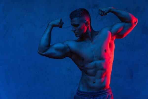 Snygg Muskulös Man Poserar Färgglada Ljus — Stockfoto