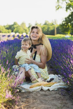 Güzel ve genç bir kadın ve küçük tatlı oğlu lavanta tarlasında