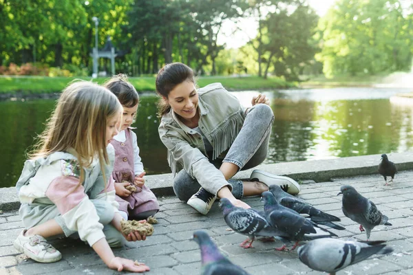 Ung Mor Och Hennes Söta Små Döttrar Matar Fåglar Stadsparken — Stockfoto