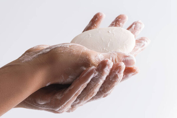Simple hygiene routine. Woman is washing her hands. Close-up of female hands with a soap. 