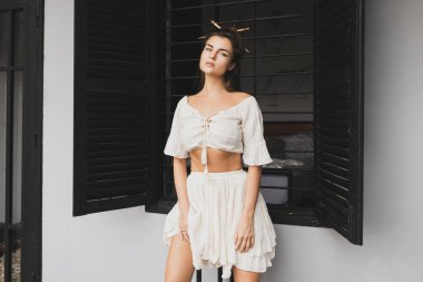 Şık saç stili ve doğal kumaş giyen seksi bir kadının portresi.