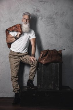 Stüdyoda poz veren şık ve yakışıklı sakallı son sınıf öğrencisi.