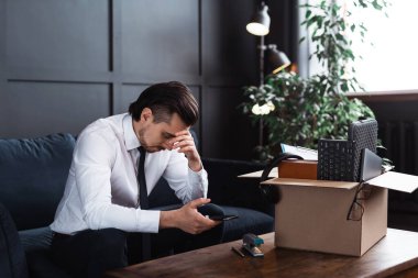 Genç bir adam işinden kovuluyor. İş adamı ve iş yerindeki kişisel eşyalarıyla birlikte karton kutu..