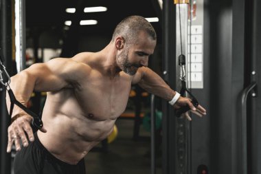 Vücut geliştirici spor salonunda çalışırken göğüs için kablo çapraz egzersizi yapıyor.
