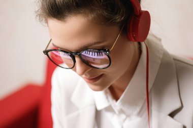 Genç kadın besteci portresi. Gözlüklü piyano tuşlarının yansıması.