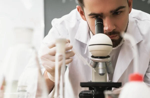 科学家在研究工作中正在实验室里使用显微镜 — 图库照片