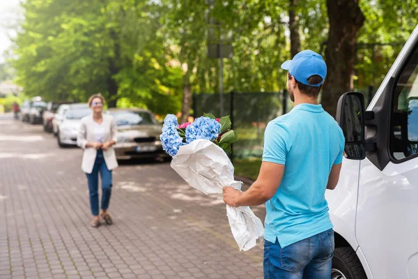 Young Professional Delivery Man Blue Uniform Delivers Flowers Woman Client — Stock Photo, Image