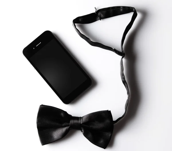 Black bowtie and smartphone — Stock Photo, Image