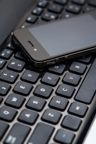 Smartphone und Laptop-Tastatur — Stockfoto