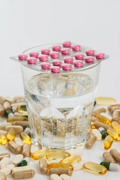 Glas en verschillende pillen — Stockfoto