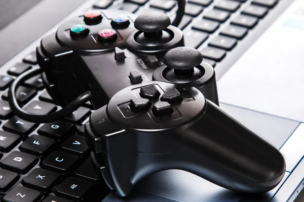 Schwarzes Gamepad liegt auf einer Laptop-Tastatur — Stockbild Gamepad liegt auf einer Tastatur — Stockfoto
