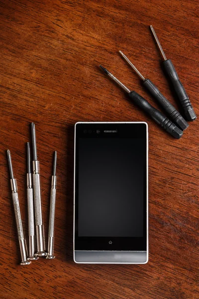 Smartphone und kleine Schraubenzieher — Stockfoto