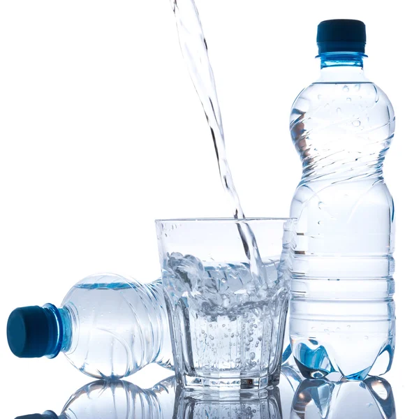 Glass and bottles with fresh water — Stock Photo, Image