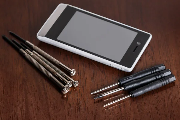 Smartphone and small screwdrivers — Stock Photo, Image