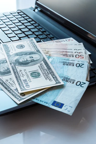 Banknotes over laptop keyboard — Stock Photo, Image