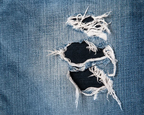 Jeans texutre with a hole — Stock Photo, Image