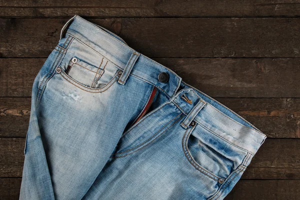 Jeansy na powierzchni drewnianych — Zdjęcie stockowe
