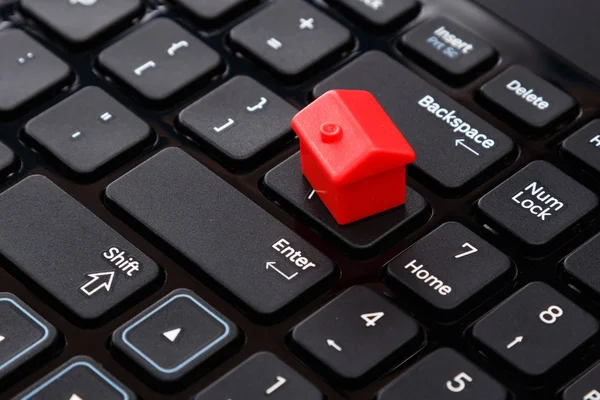 Pequena casa de brinquedo sobre teclado — Fotografia de Stock