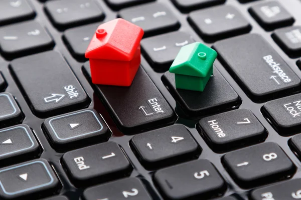 Small toy houses over keyboard — Stock Photo, Image