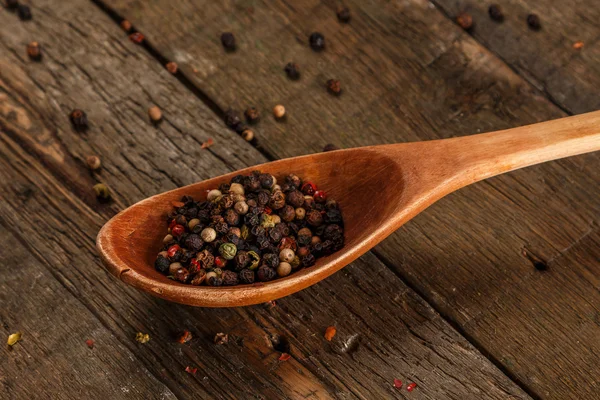 Cucchiaio di legno e semi di pepe essiccati — Foto Stock
