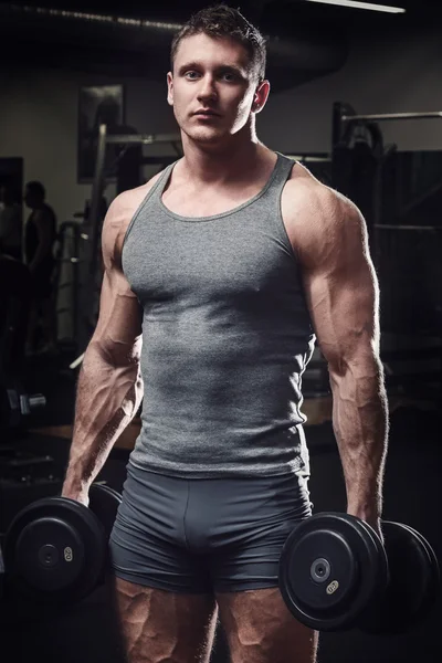 Uomo muscoloso con manubri — Foto Stock