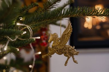 Işıltılı Pegasus Süslemesi Noel ağacında asılı, şömine Arkaplanlı.