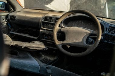 Hurdalıkta terk edilmiş ve tozlu bir arabanın içinde..