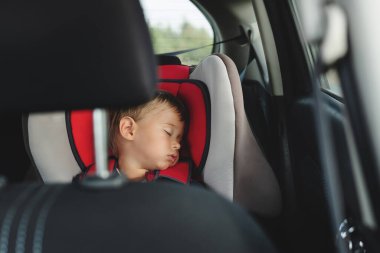 Sevimli çocuk bir aracın içinde araba koltuğunda huzur içinde uyuyor..