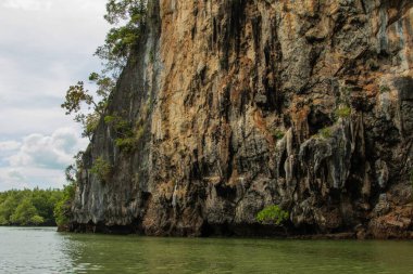 Kireç taşı kayalıkları zümrüt yeşili suların üzerinde dramatik bir şekilde yükselir..