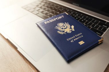 ABD pasaportu klavyede, modern seyahat, dijital kimlik doğrulaması ve uluslararası belgeleri sembolize ediyor.