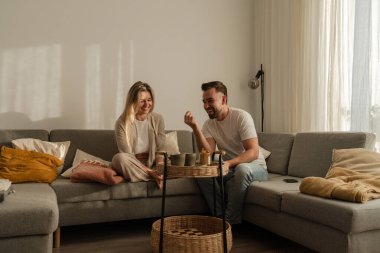 Çift Evde Kanepede Atıştırmalık ve Sohbetin Tadını Çıkartıyor.