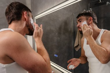 Modern Banyo Aynasında Led Light ile Tıraş Kremi Uygulayan Adam.