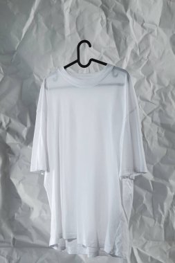 Askıda Kırışık Kağıt Arkaplanlı Düz Beyaz Tişört.