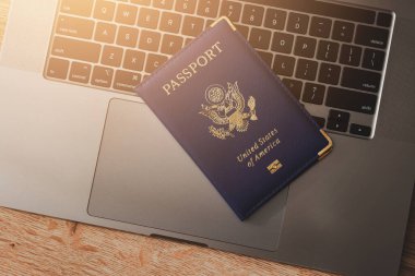ABD pasaportu klavyede, modern seyahat, dijital kimlik doğrulaması ve uluslararası belgeleri sembolize ediyor.