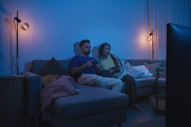 Çift, geceleri rahat oturma odasında video oyunu oynuyor..