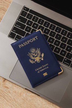 ABD pasaportu klavyede, modern seyahat, dijital kimlik doğrulaması ve uluslararası belgeleri sembolize ediyor.