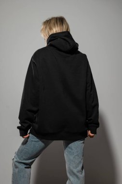 Büyük boy siyah kapüşonlu giyen, boş yeri olan bir kadın..