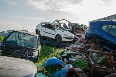 Hurdalıkta hasarlı ve terk edilmiş bir araba yığını..