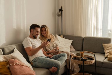 Smartphone kullanarak ve kahve içerek birlikte oturan mutlu çift..