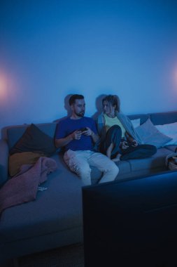 Çift, geceleri rahat oturma odasında video oyunu oynuyor..