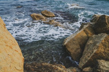Sahil manzarası kıyı şeridi boyunca pürüzlü kayalarla dolu..