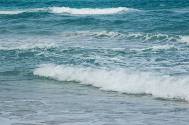 Okyanus dalgaları yavaşça kıyıya vuruyor..