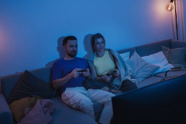 Çift, geceleri rahat oturma odasında video oyunu oynuyor..