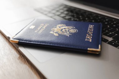 ABD pasaportu klavyede, modern seyahat, dijital kimlik doğrulaması ve uluslararası belgeleri sembolize ediyor.