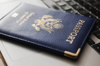 ABD pasaportu klavyede, modern seyahat, dijital kimlik doğrulaması ve uluslararası belgeleri sembolize ediyor.