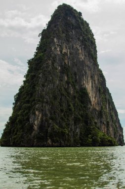 Kireç taşı kayalıkları zümrüt yeşili suların üzerinde dramatik bir şekilde yükselir..