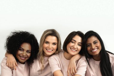 Birbirlerine gülümseyen ve kucaklayan bir grup genç kadın, dostluğu, birliği ve kapsayıcılığı sembolize ediyor..