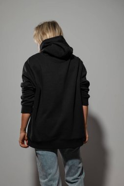 Büyük boy siyah kapüşonlu giyen, boş yeri olan bir kadın..