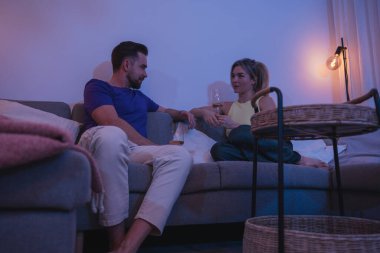 Rahatlamış çift akşamları evde şarabın tadını çıkarıyor..